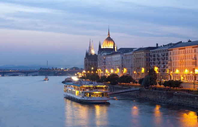 Night view of Budapest with small cruise boat