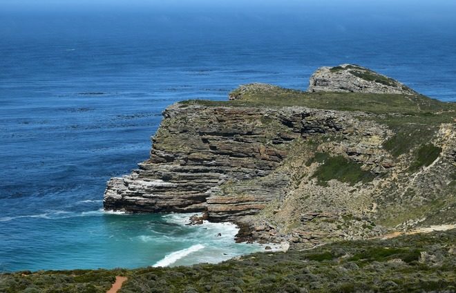 Appreciate Cape Point, a spectacular sight with towering stone cliffs, breathtaking bays, beaches, and rolling green hills and valleys.